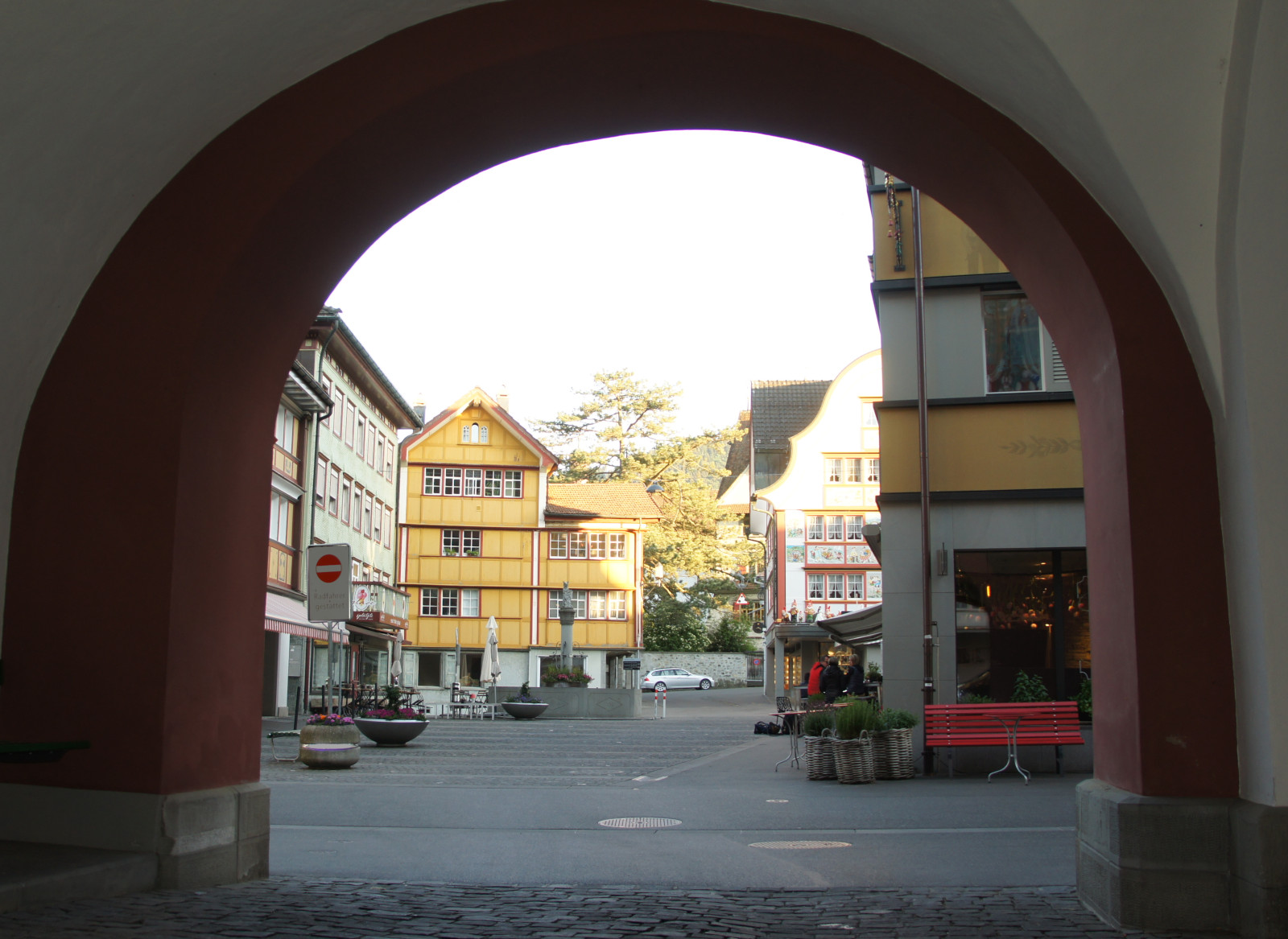 Blick vom Rathausbogen über den Platz und Dorfbrunnen zum gelben Haus Marwies